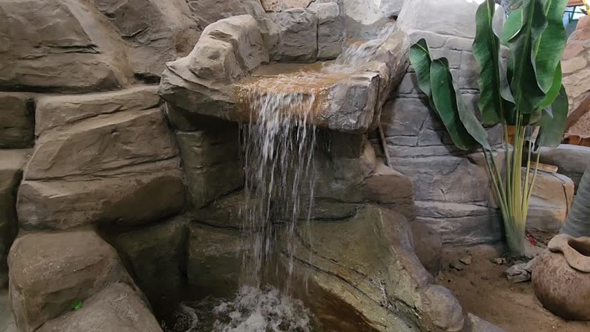 Filming a video of the waterfall among the rocks