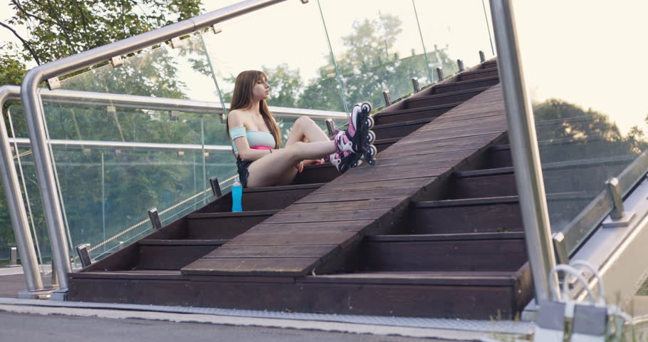 Girl picks up a bottle of drink after playing sports