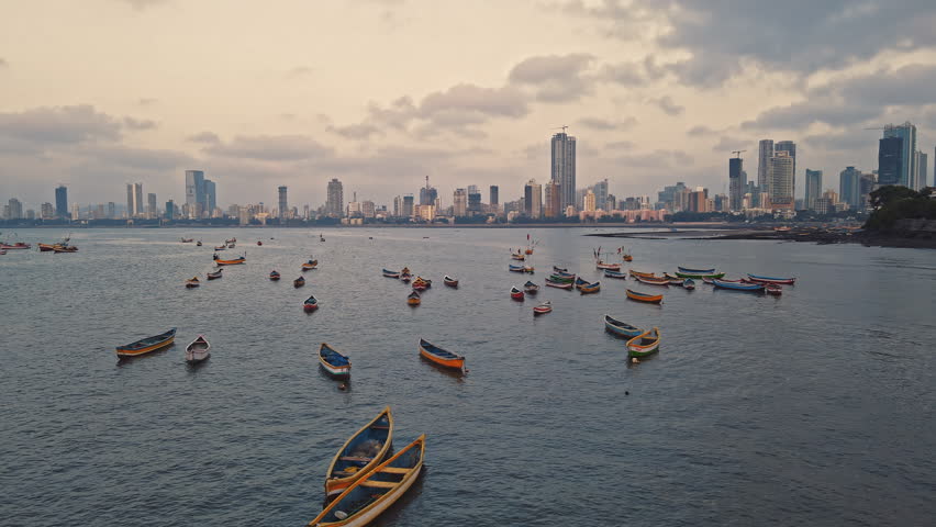 Aerial view of Gateway of India. Cityscape of old Mumbai town. Early morning weather on the seashore of Mumbai. Drone view of Taj Palace Hotel. Fishings boats sail in the sea during sunrise. Royalty-Free Stock Footage #1101468721