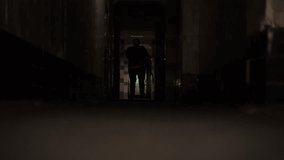 Ice hockey player walking alone through the dark hallway towards rink. Atmospheric video of a hockey player