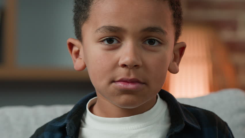 Portrait sad cute little African American boy looking down look at camera. Close up ethnic multiracial multiethnic child orphan pupil son baby schoolboy schoolchild schoolkid upset serious kid face | Shutterstock HD Video #1101471915