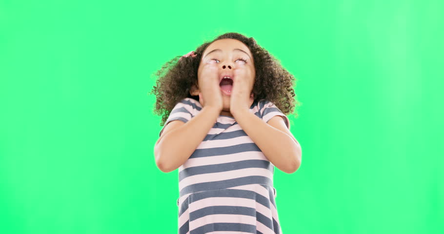 Girl, child and screaming on green screen in studio isolated on a background. Excited, happy face and kid shouting for joy, happiness and spinning for celebration, good news or cheering on chroma key