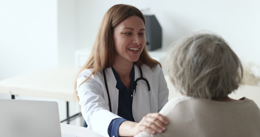 Happy optimistic doctor woman giving psychological support to old senior female patient, touching shoulder, talking, speaking. Elderly lady visiting geriatric practitioner for healthcare checkup Royalty-Free Stock Footage #1101476239