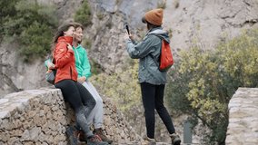 Video of cute family takinf photo with smartphone on a bridge in mountain forest