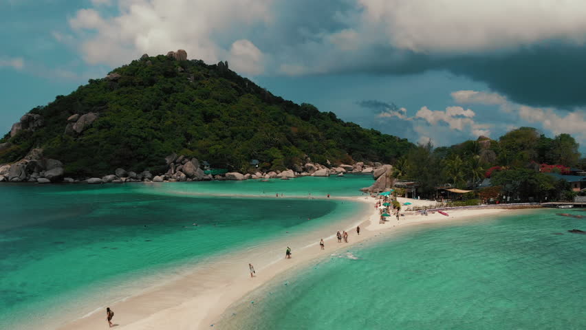 Drone flying up in Koh Tao in Southern Thailand with blue ocean and Koh Nang Yuan island. Summertime paradise island with thin sandy strip. Place for perfect snorkeling. High quality 4k footage Royalty-Free Stock Footage #1101485811