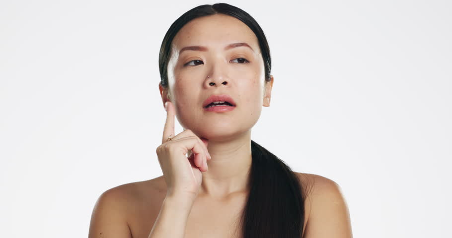 Skincare, thinking and Asian woman in studio with a beauty, self care and natural routine. Question, doubt and portrait of a unsure female model with dermatology facial treatment by white background. | Shutterstock HD Video #1101488511
