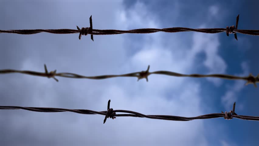 Barbed wire slider oncept clip with speed clouds background. Royalty-Free Stock Footage #1101490645