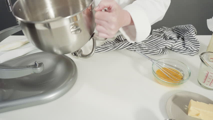 Mixing ingredients in a kitchen standing mixer to bake cinnamon rolls.