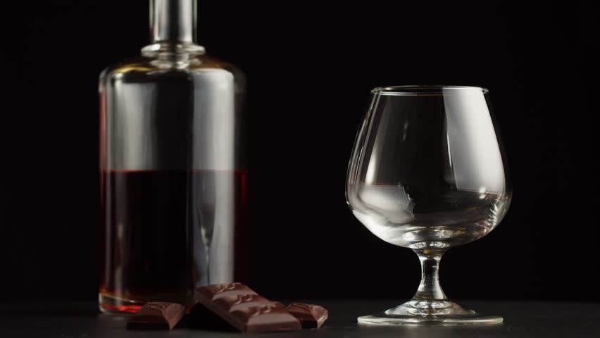 Brandy or whiskey close-up. Luxury cognac on black background. Alcohol amber drink, drinking rum, liqour beverage in glass.