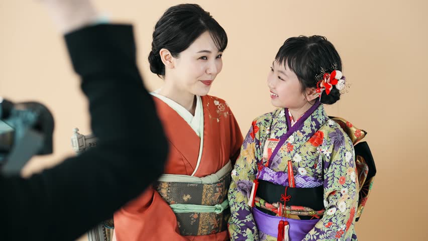Mother and daughter in Japanese kimono. Commemorative photo in Japanese clothes. Photo studio. Royalty-Free Stock Footage #1101496425