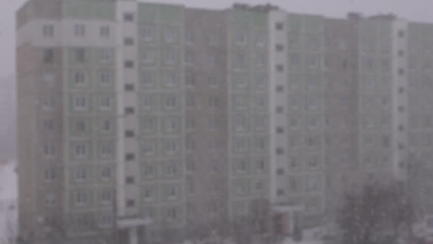 Winter snowfall, Snowstorm in the city, snowflakes fly against the background of houses