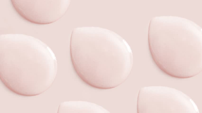 Round drops of transparent gel serum on beige background | Shutterstock HD Video #1101500157