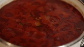Mexican traditional dish is boiling in white pans. Home made food concept. Macro video of spicy food