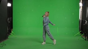 Attractive girl sings into a microphone and moves to the beat of music on Green screen. Young white woman having fun at karaoke - Powered by Shutterstock - Get 15% off with code: PIKWIZARD15