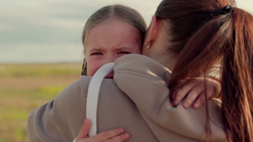 Child is crying in park in arms of mom. Mommy soothes baby. Family mother and child with tears in their eyes hugs their mother, emotionally. Loving young mother hugs and soothes her little daughter. Royalty-Free Stock Footage #1101505165