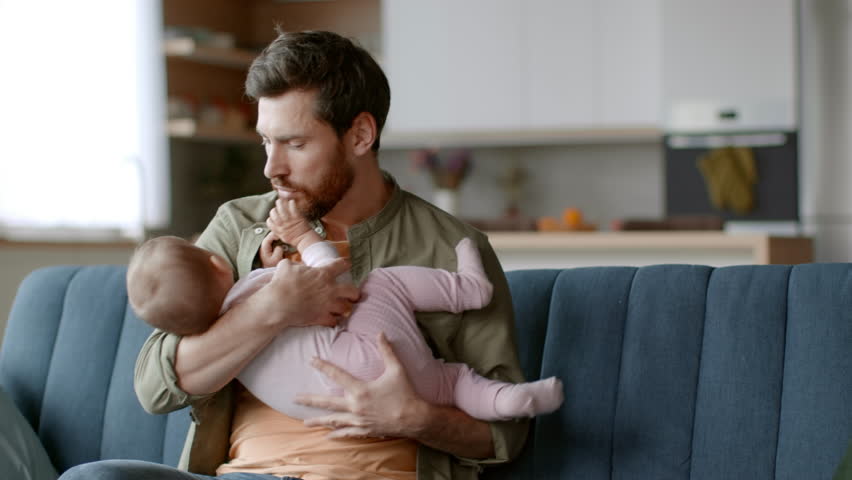 Fatherhood difficulties. Desperate father trying to calm down his nervous crying baby daughter, little girl screaming, suffering from colic or teething pain, tracking shot, slow motion, free space Royalty-Free Stock Footage #1101507953