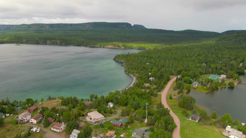 Aerial view of blue water Lake Superior with green Canadian coastline Sleeping Giant Silver Islet Evergreen Trees Mountain Cliffs in background