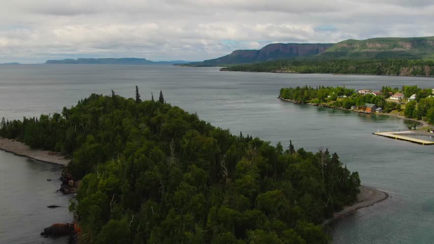 Aerial view of blue water Lake Superior with green Canadian coastline Sleeping Giant Silver Islet Evergreen Trees Mountain Cliffs in background