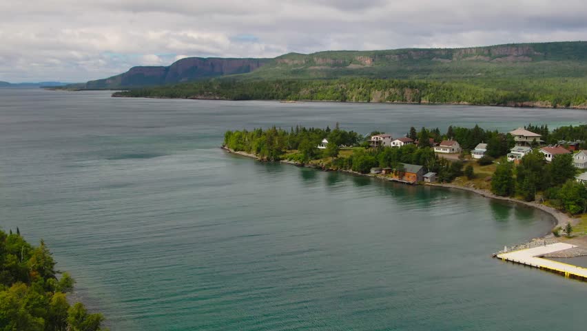 Aerial view of blue water Lake Superior with green Canadian coastline Sleeping Giant Silver Islet Evergreen Trees Mountain Cliffs in background