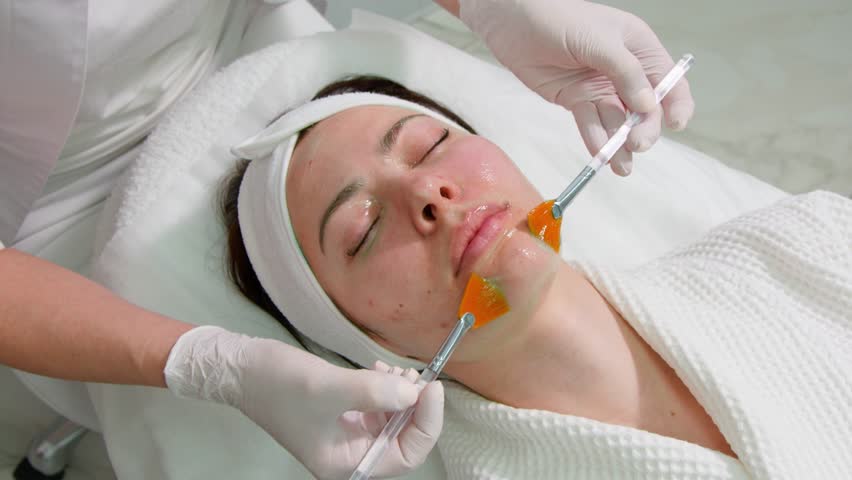 Cosmetologist applies a nourishing mask to a young woman in a spa salon. | Shutterstock HD Video #1101527465
