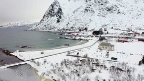 4k drone forward video (Ultra High Definition) of Valberg village, Norway, Europe. Snowy winter scene of Lofoten Islands. Beautiful morning view of Velberg church.