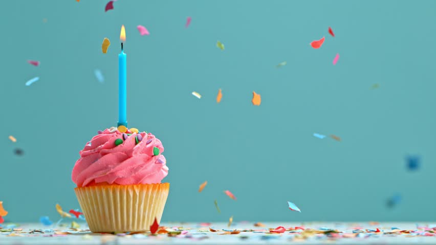 Birthday Cup Cake With Burning Colorful Candle on Pastel Blue Background. Super Slow Motion, 1000 FPS. Royalty-Free Stock Footage #1101538283