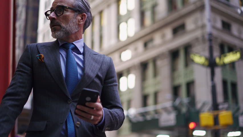 Excited mature financial expert in suit and eye glasses checks quotes on stock exchange using smartphone application. Businessman celebrate Successful investments in trading while using cellphone app Royalty-Free Stock Footage #1101543897