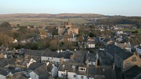 Slow Motion clip of the Cumbrian medieval village of Cartmel showing the historic Cartmel Priory at sunset on a winters day.
