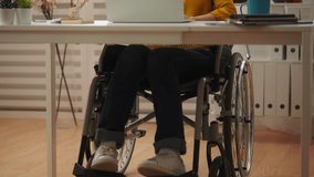 Young woman wheelchair user having video conference on laptop, work from home