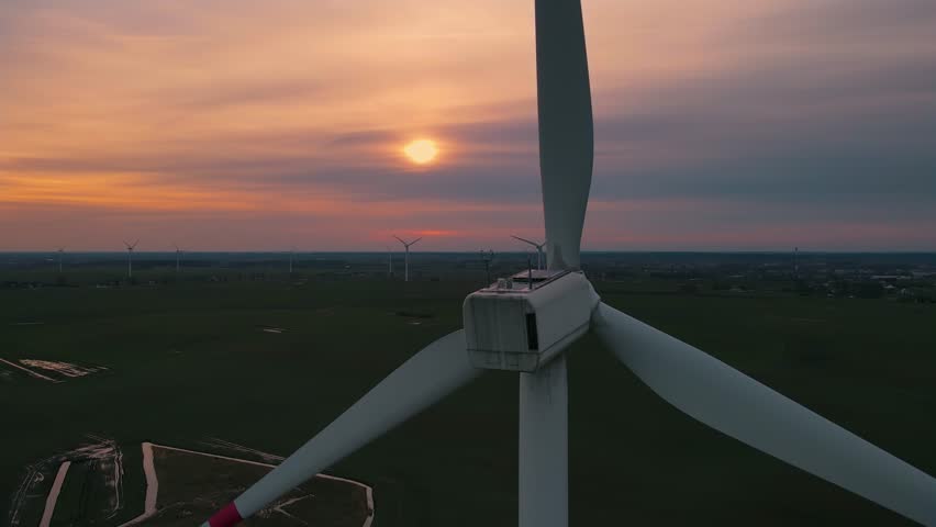 Aerial view of farm with wind turbines standing on wheat field. Drone flies over windmill park at sunset. Electricity, ecological saving and alternative power source | Shutterstock HD Video #1101545637