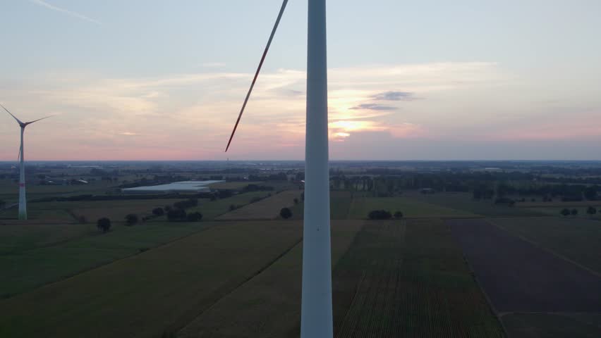 Close-up view windmill farm from drone. Cinematic aerial view of large wind turbines producing clean sustainable energy, clean energy future. Windmill farm in a field at sunrise with fog aerial view | Shutterstock HD Video #1101546167