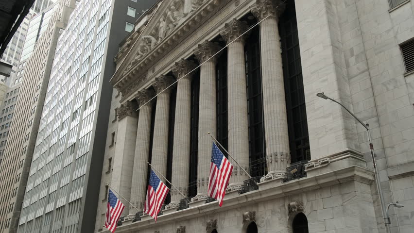 Famous Wall street and the building in New York, New York Stock Exchange with patriot flag. Wall Street road sign in the corner of New York Stock Exchange. New York Stock Exchange Royalty-Free Stock Footage #1101546353