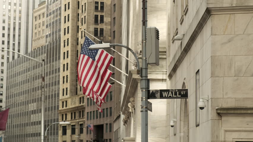 Famous Wall street and the building in New York, New York Stock Exchange with patriot flag. Wall Street road sign in the corner of New York Stock Exchange. New York Stock Exchange Royalty-Free Stock Footage #1101546357