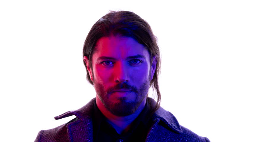 A young man looking at the camera with red and blue mixed lighting. A good fashion or technology concept