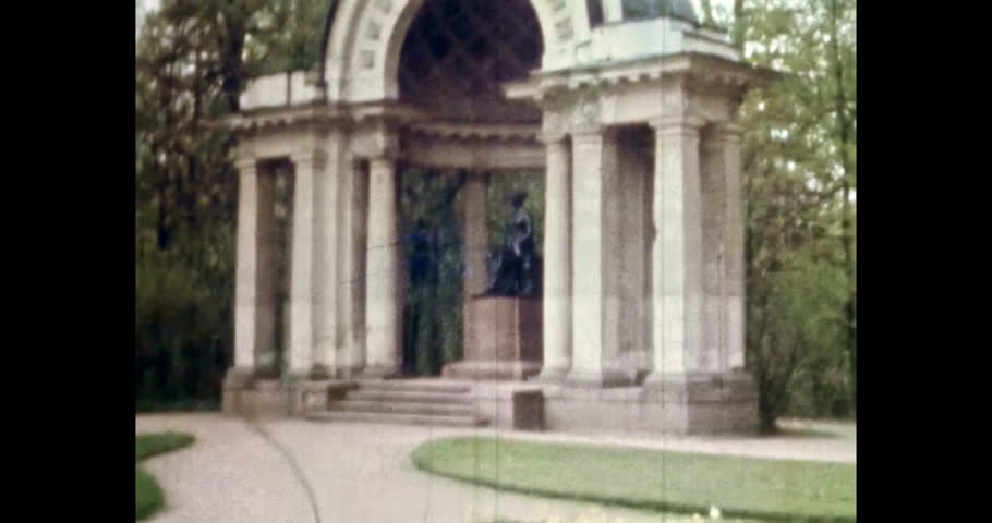 Columns monument woman sculpture in summer park close up. Pavlovsky park in green spring. Architecture building in city park landscape. Vintage color film. Old culture archive. Retro Petersburg 1980s