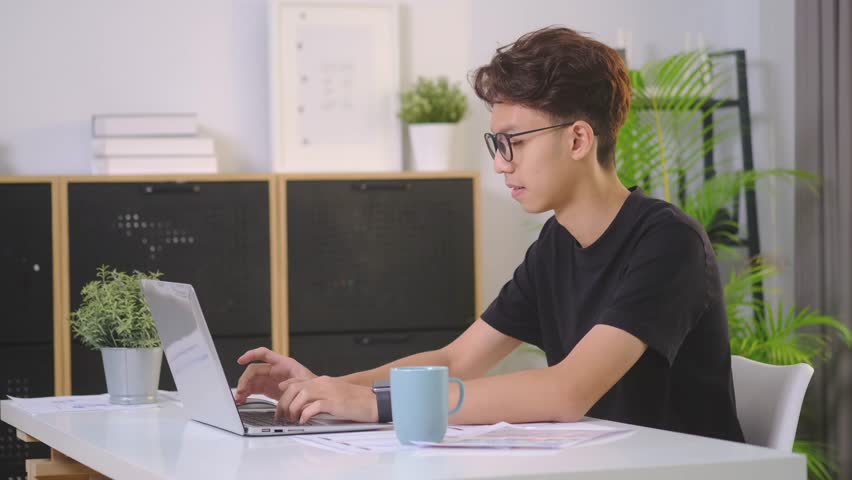Young student man in glasses watching online lecture or browsing internet on laptop computer. | Shutterstock HD Video #1101549515