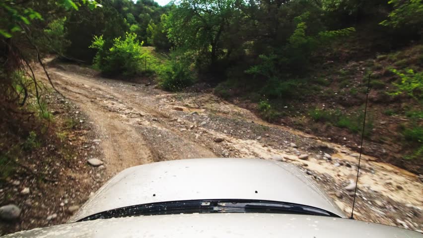 Front view jeeping 4WD on narrow dried river valley road outdoors. Off-road tour in extreme condition concept Royalty-Free Stock Footage #1101550639
