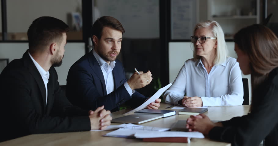 Young and mature staff listening team leader, company boss make speech, reporting about sales results, strategy, corporate goals at group meeting in conference room. Negotiations, training, business Royalty-Free Stock Footage #1101557179