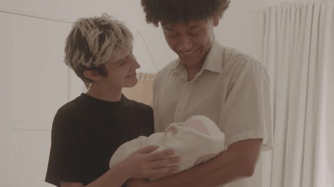 Happy Couple Holding Newborn Baby In Nursery Together 스톡 비디오