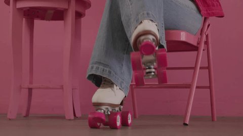 Woman in Pink Rollerskates Sitting in a Pink Chair in a Retro Pink Room Video Stok