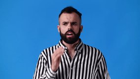 4k video of one man with negative facial expression on blue background.