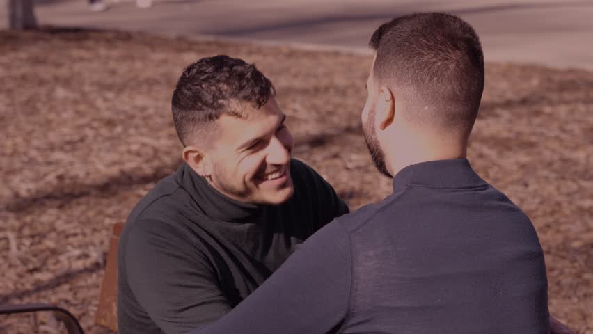 gay couple in the park, cuddling, loving and playful