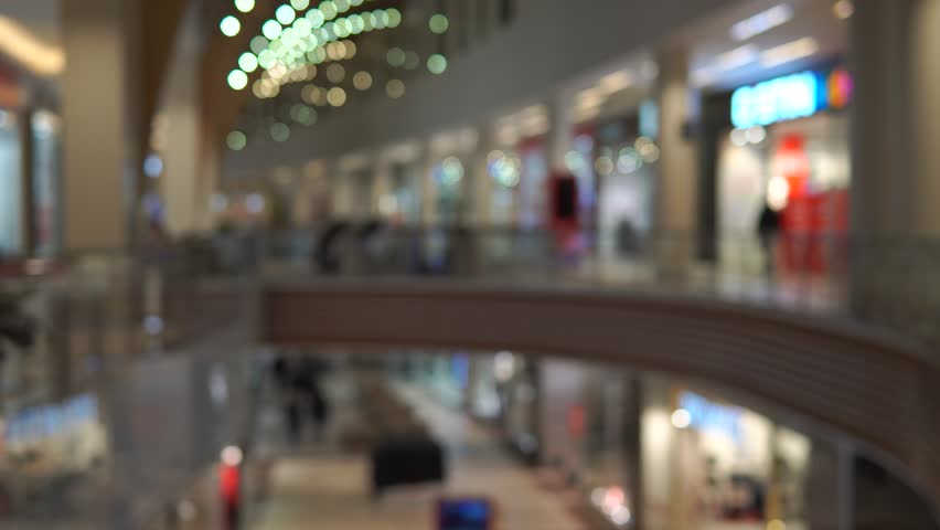 People are walking in the mall. Image out of focus