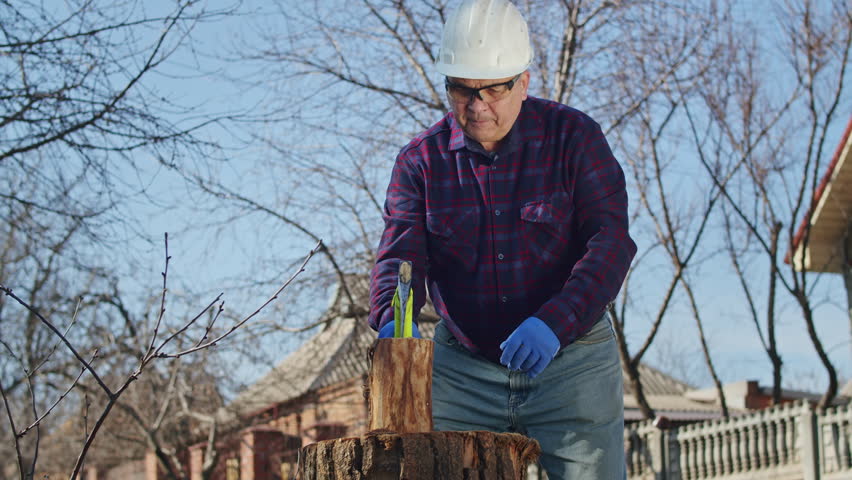 Experience meets safety in this inspiring video, as an old man and his family work together to gather firewood for their home, using an axe and tape to ensure a job well done | Shutterstock HD Video #1101597271