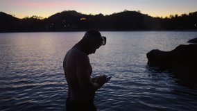 Young man taking a video for social media of a beautiful sunset in an exotic island in thailand