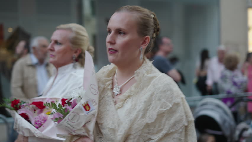 Two adult blonde women walk through the crowd in Zaragoza