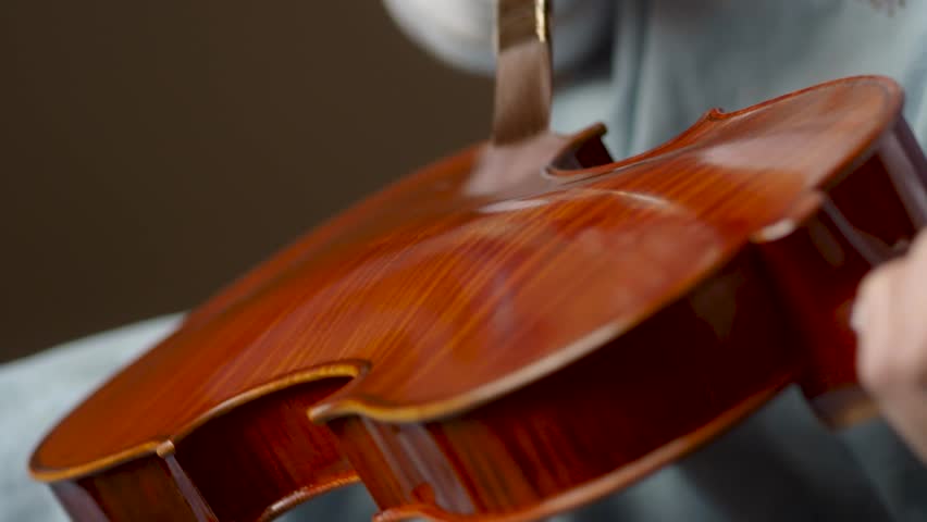 violin maker artisan varnishing with self produced paint, final brush strokes to a handmade classic violin 4k footage Royalty-Free Stock Footage #1101600981