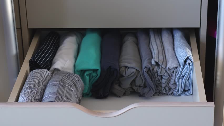 Women's hands folded jeans folded vertically into a drawer in the closet. The concept of organizing and storing clothes. Royalty-Free Stock Footage #1101602981