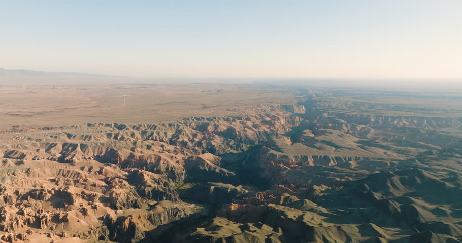 Charyn canyon with river in Kazakhstan. Oasis around the river among arid dry sand landscapes. Aerial drone view at summer sunny sunset. | Shutterstock HD Video #1101607709