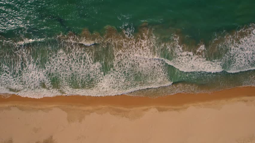 Aerial top down view of waves crashing on a white sand beach in Tarifa, Spain. | Shutterstock HD Video #1101611123